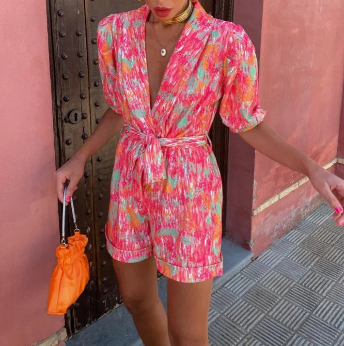 Women's wedding guest romper with puff sleeves & belt. Elegant occasion wear, perfect for summer parties.