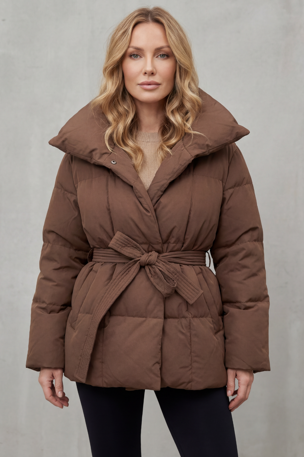 Warm women's puffer jacket with an adjustable belt, ideal for winter. Features a stylish oversized collar.