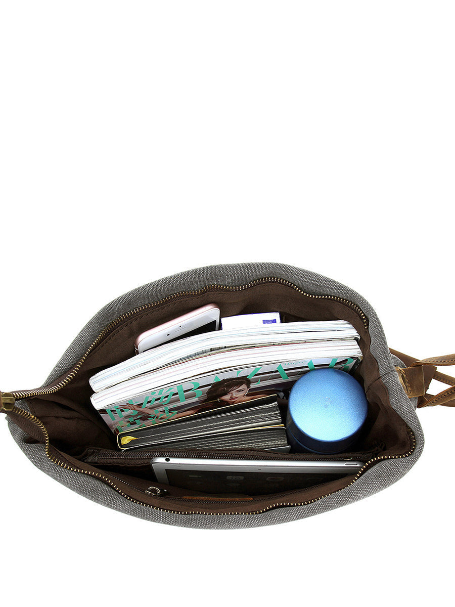 Chic women's tan asymmetrical slouchy shoulder bag with a secure button closure and adjustable strap.