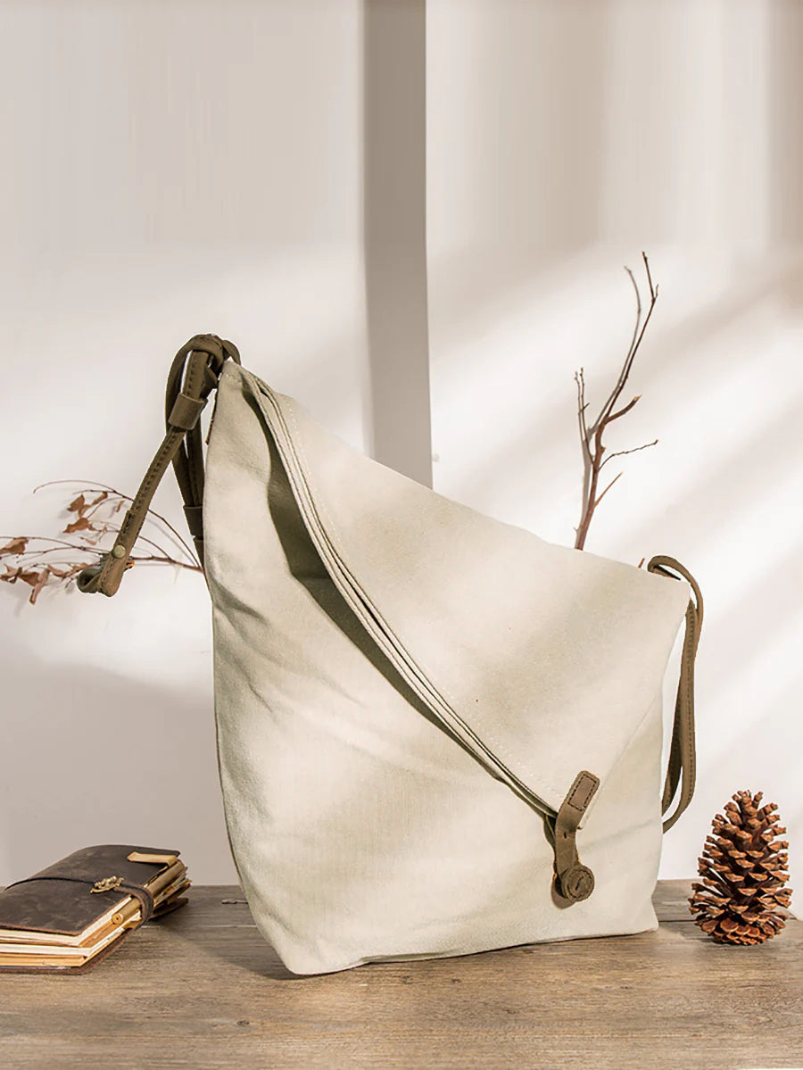 Stylish women's tan slouchy crossbody bag, asymmetrical design, featuring an adjustable strap.