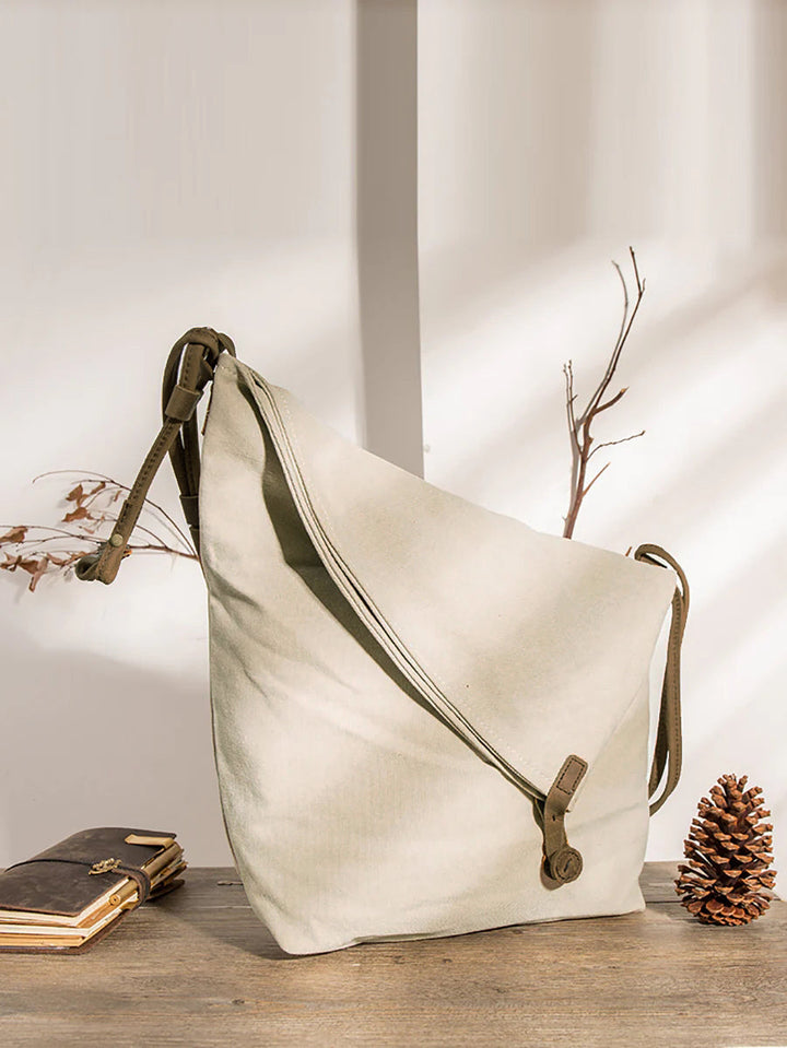 Stylish women's tan slouchy crossbody bag, asymmetrical design, featuring an adjustable strap.