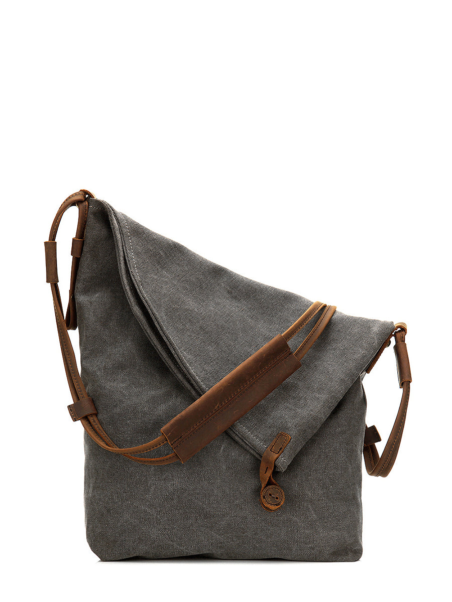 Detail of the button closure on a women's grey asymmetrical slouchy bag, practical & fashionable.