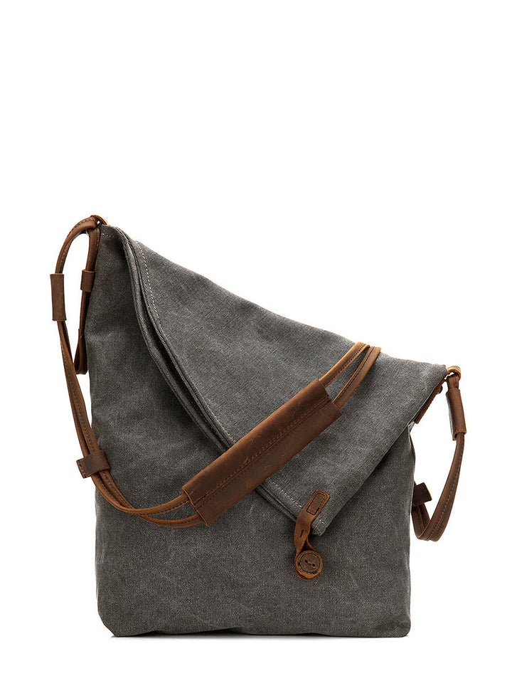 Detail of the button closure on a women's grey asymmetrical slouchy bag, practical & fashionable.