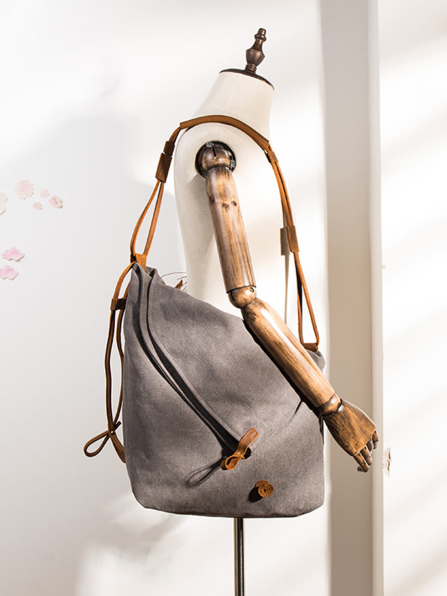 Women's navy slouchy shoulder bag with an asymmetrical cut and a long, adjustable strap.