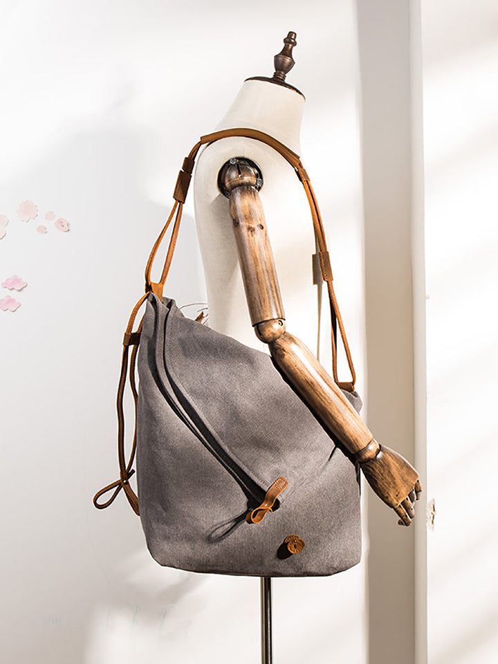Women's navy slouchy shoulder bag with an asymmetrical cut and a long, adjustable strap.