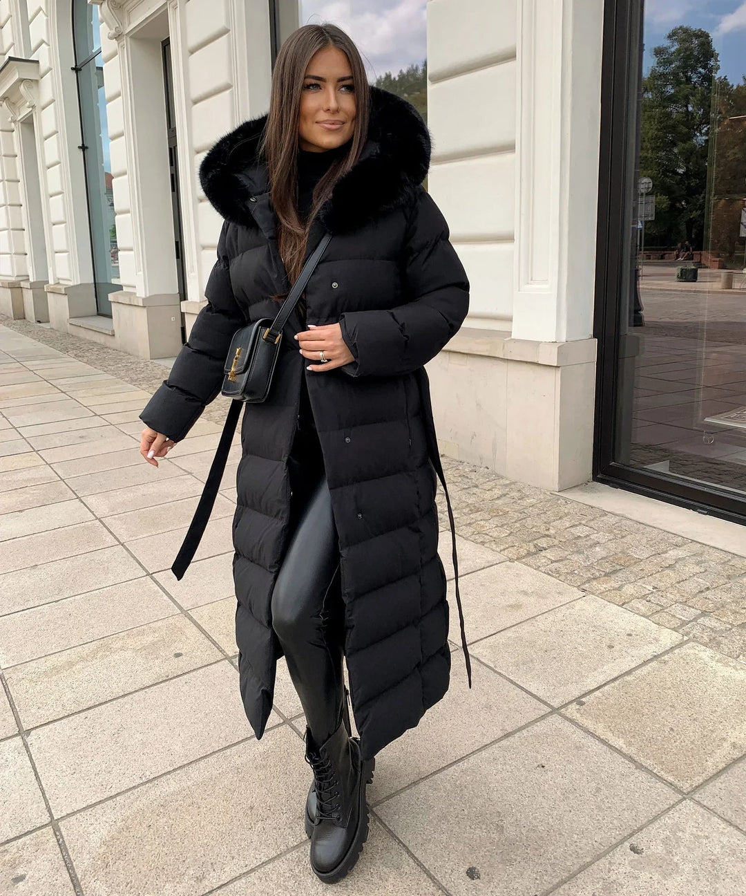 Stylish women's quilted long black belted puffer coat, perfect for cold weather.