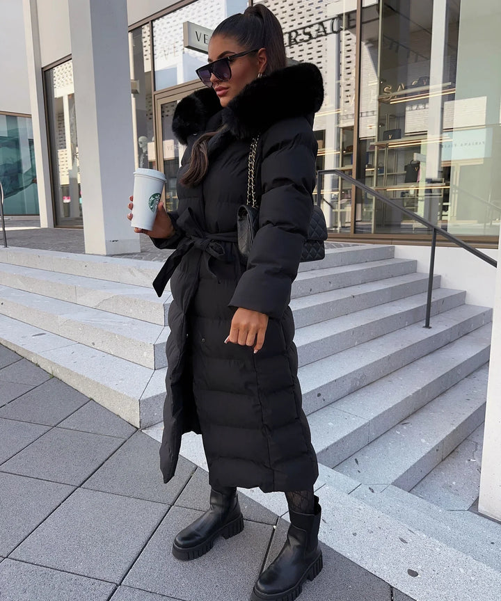 Elegant women's black maxi length puffer coat with belt, providing ultimate winter warmth.