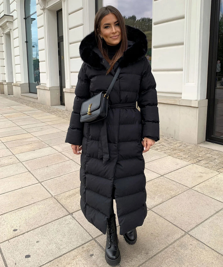 Full-length women's black belted puffer jacket, a warm quilted winter coat for women.