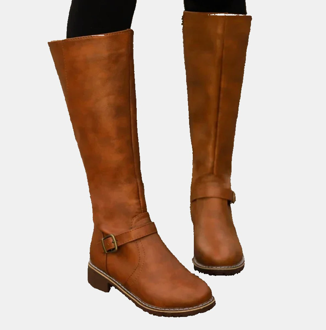 Side view of women's tall knee high riding boots featuring elegant buckle straps & comfortable low heel.