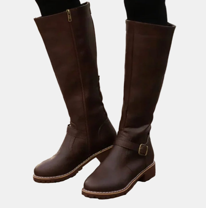 Stylish women's winter boots, knee-high design with multiple buckle straps and a practical low heel.