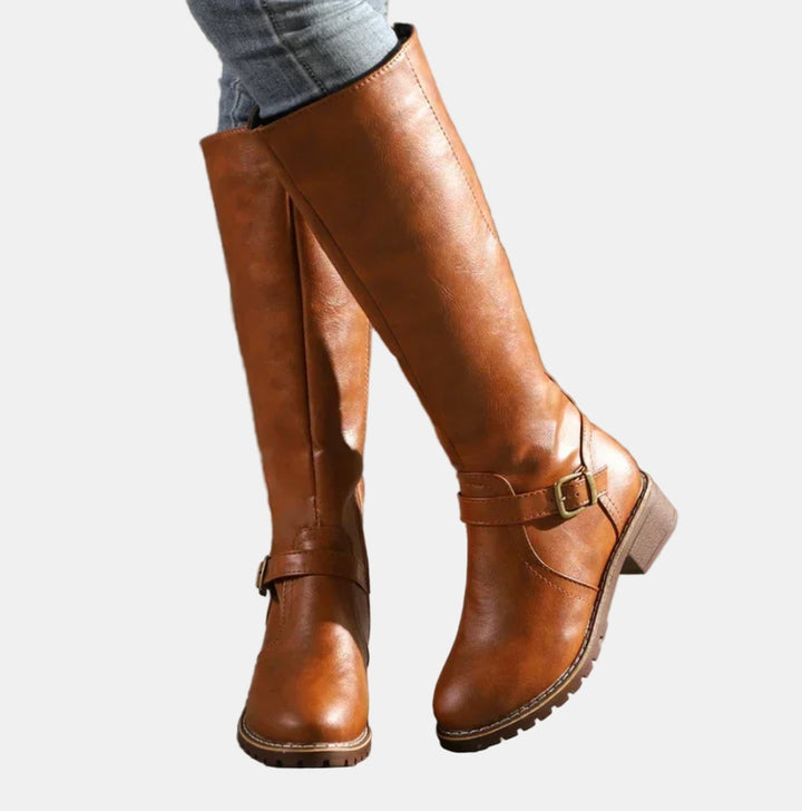Close-up of women's buckle-strap riding boots showing detail of straps, low heel & knee-high shaft.