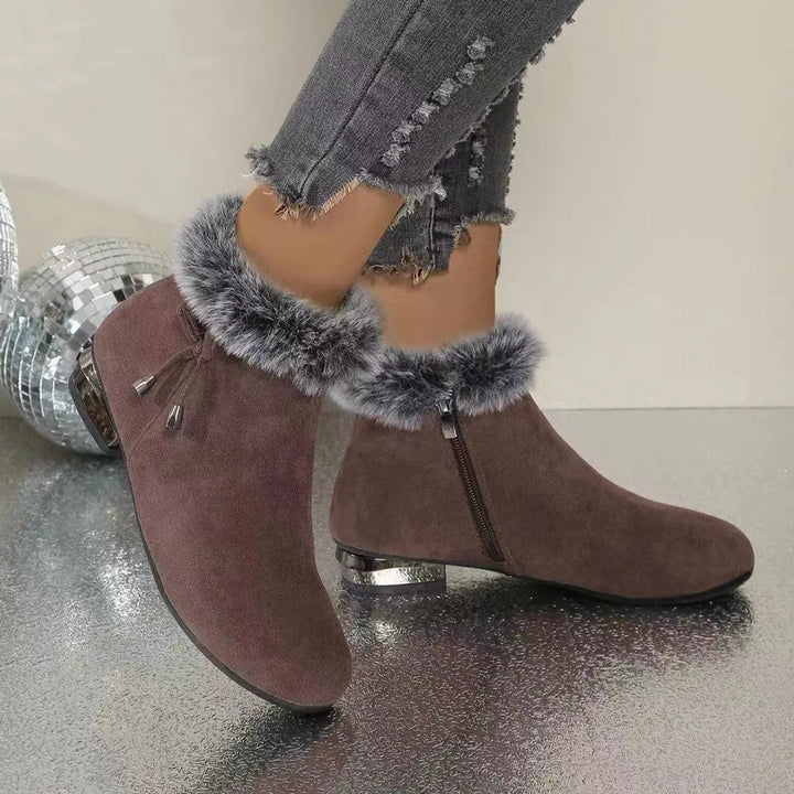 Comfortable women's fur-trim flat ankle boots in brown. Stylish, warm winter footwear for cold weather days.