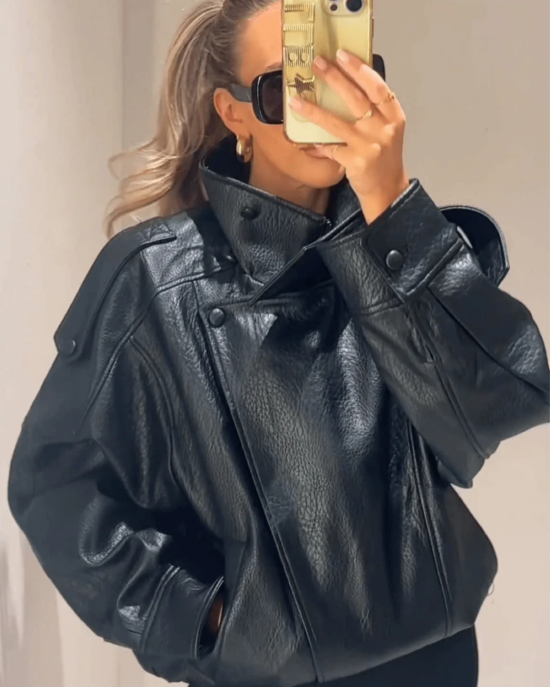 Modern women's black leather jacket, high neck design for a sleek & fashionable outerwear look.