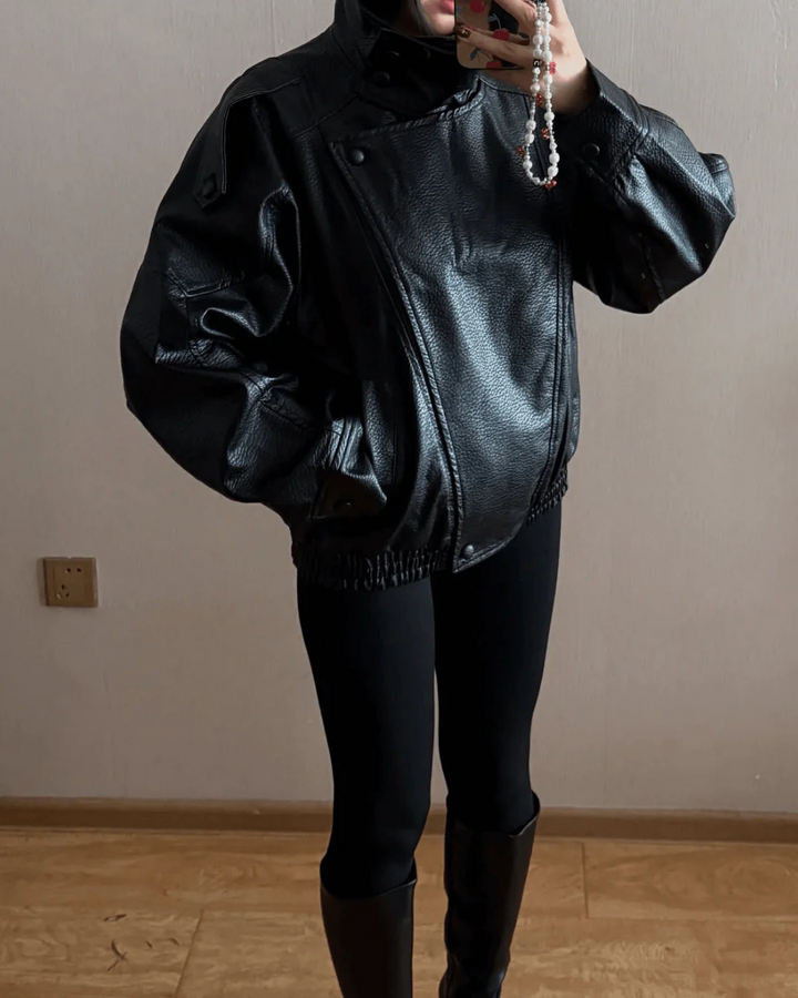 Close-up of the high neck on a women's sleek black leather jacket, modern fashion detail.