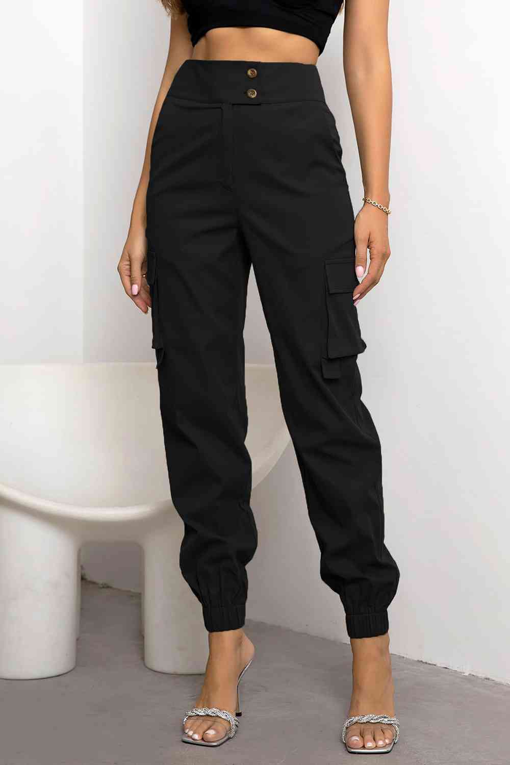 Women's black high-waist cargo trousers, urban style with multiple pockets & tapered fit for comfort.