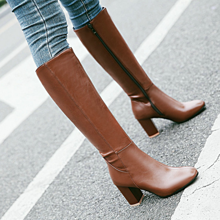 Fashionable women's block heel boots reaching the knee, complete with a convenient zip closure.