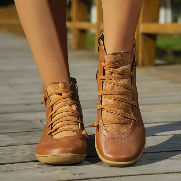 Versatile women's flat ankle boots with lace-up detail & side zip, suitable for many casual styles. Comfort focus.