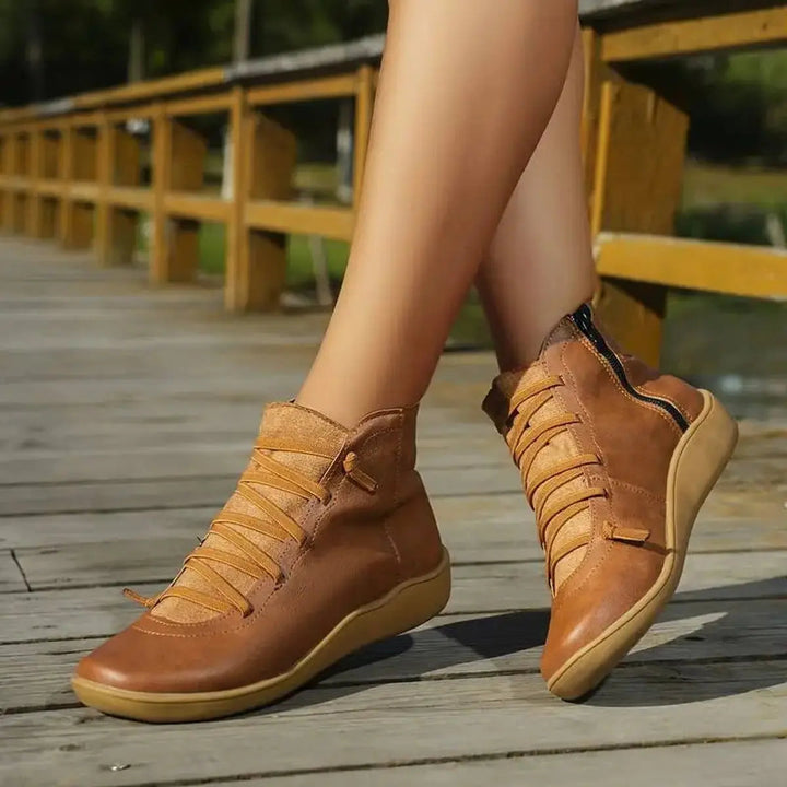 Women's flat ankle boots with detailed lace-up front and practical side zip for easy wear. Comfort footwear.