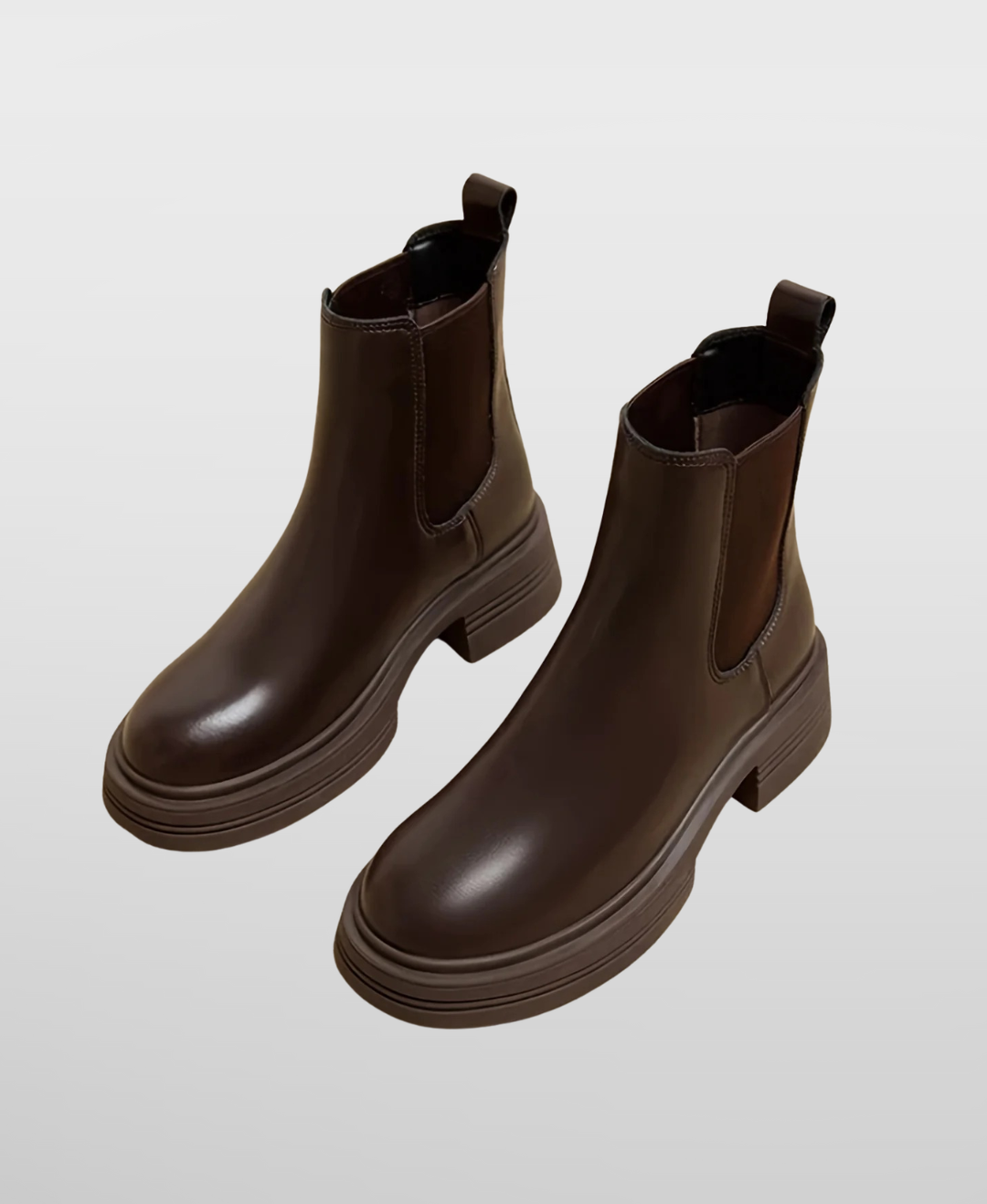 Women's black leather Chelsea ankle boots with comfortable block heel, elastic side panels, and round toe. Slip-on fall/winter fashion.