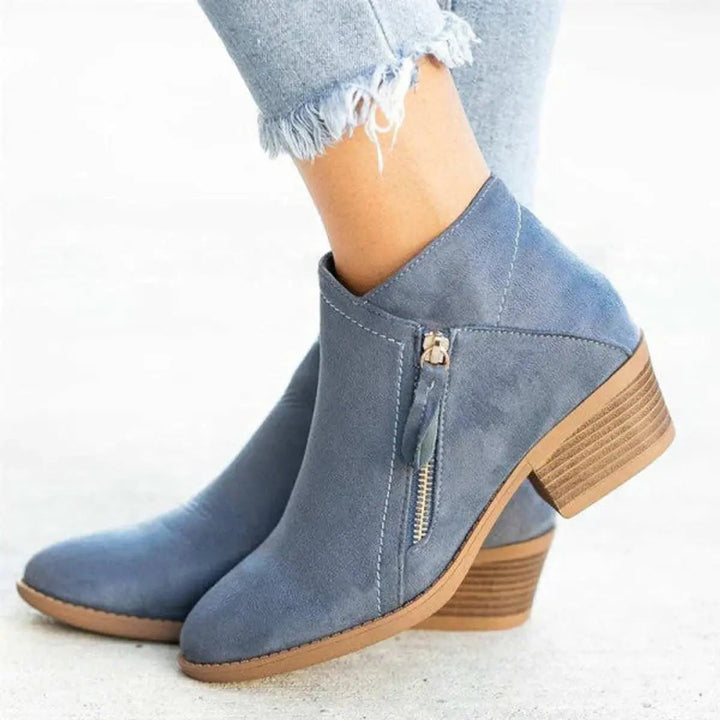Women's black low-heel zip-up ankle boots with block heel. Comfortable and chic for everyday casual style.