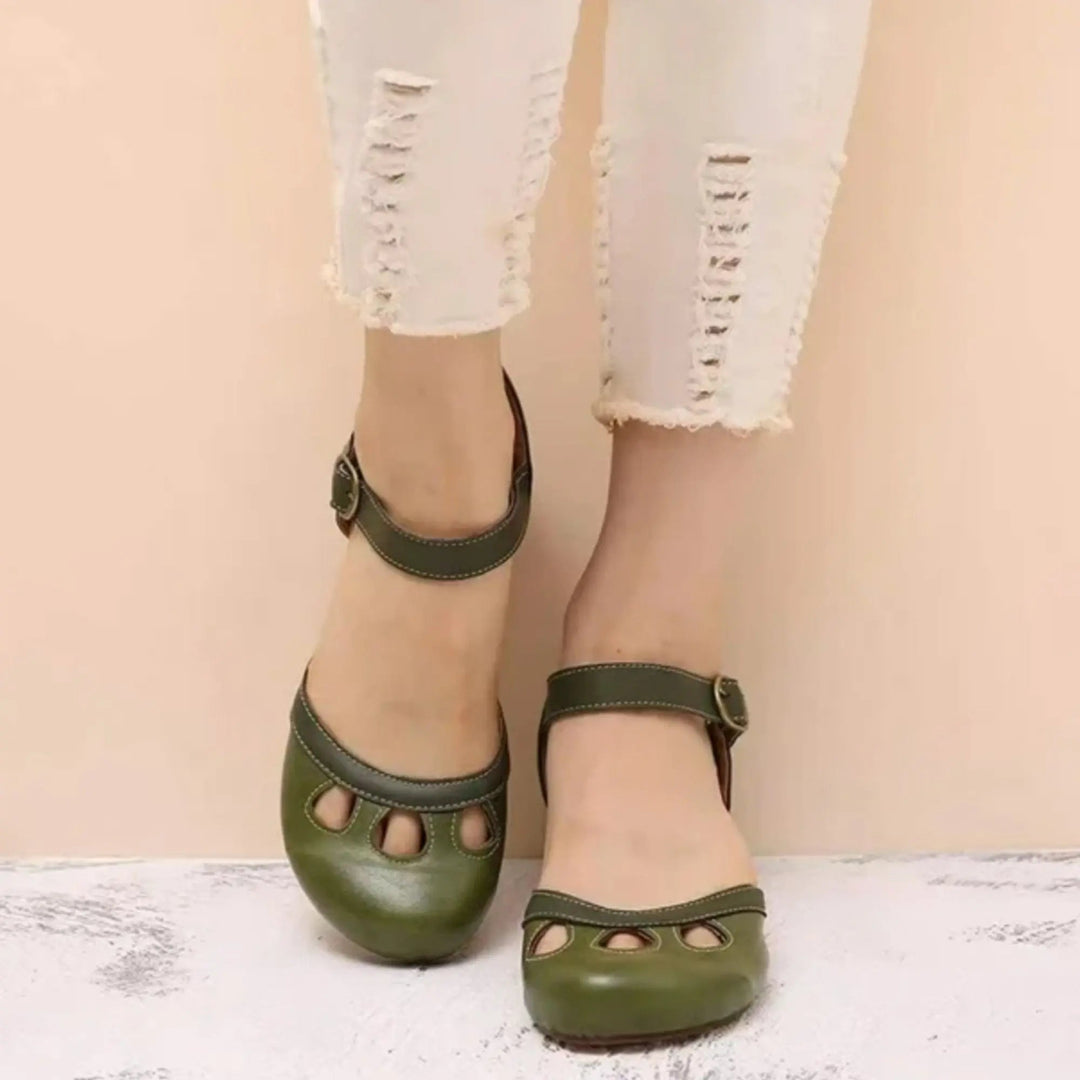 Women's black Mary Jane flats with ankle strap, cutout details, and comfortable design for casual everyday wear.