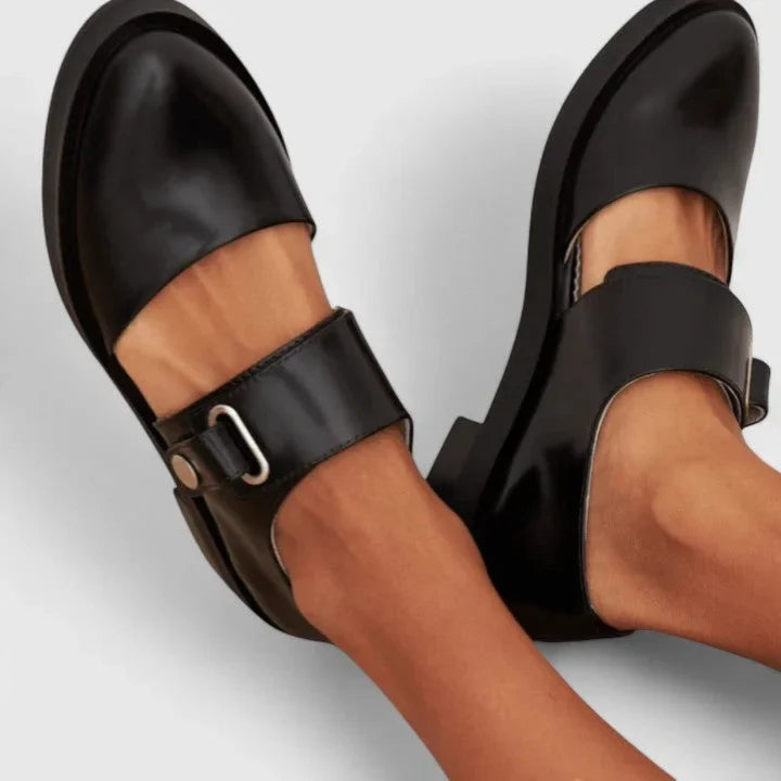 Women's black Mary-Jane flats with elegant side cut-outs, perfect for comfort and classic style.