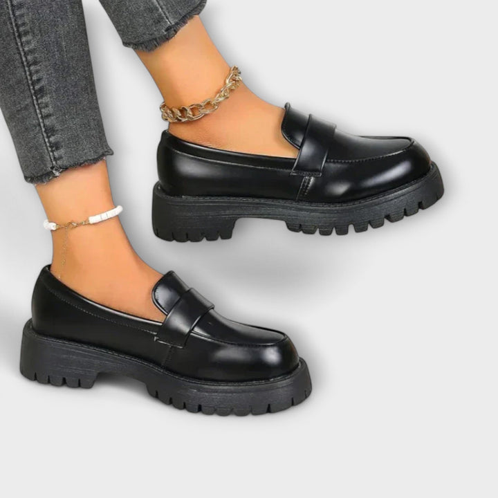 Black orthopaedic slip-on loafers for women, offering superior comfort & foot support. Versatile for casual to dressy.
