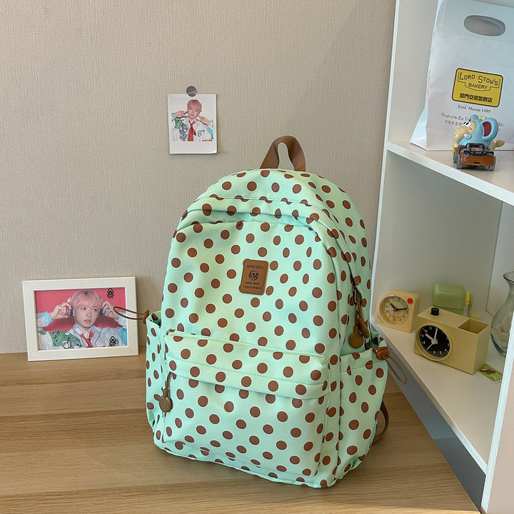 Black & white polka dot women's casual backpack, durable fabric, great for school, travel, or daily commute.
