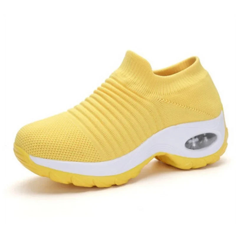 Black slip-on casual sneakers for women, with air-cushion sole, offering arch support & comfort.