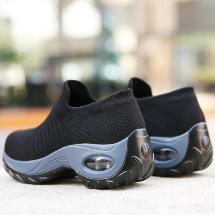 Supportive black women's slip-on sneakers, cushioned sole, ideal for comfortable daily walking.