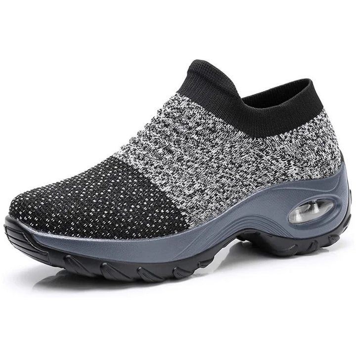 Black slip-on sneakers for women, featuring air-cushion sole & arch support for comfortable walking.