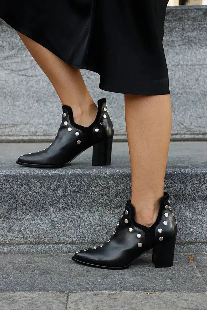 Edgy women's black studded ankle boots featuring a chunky block heel & pointed toe for a bold fashion statement.