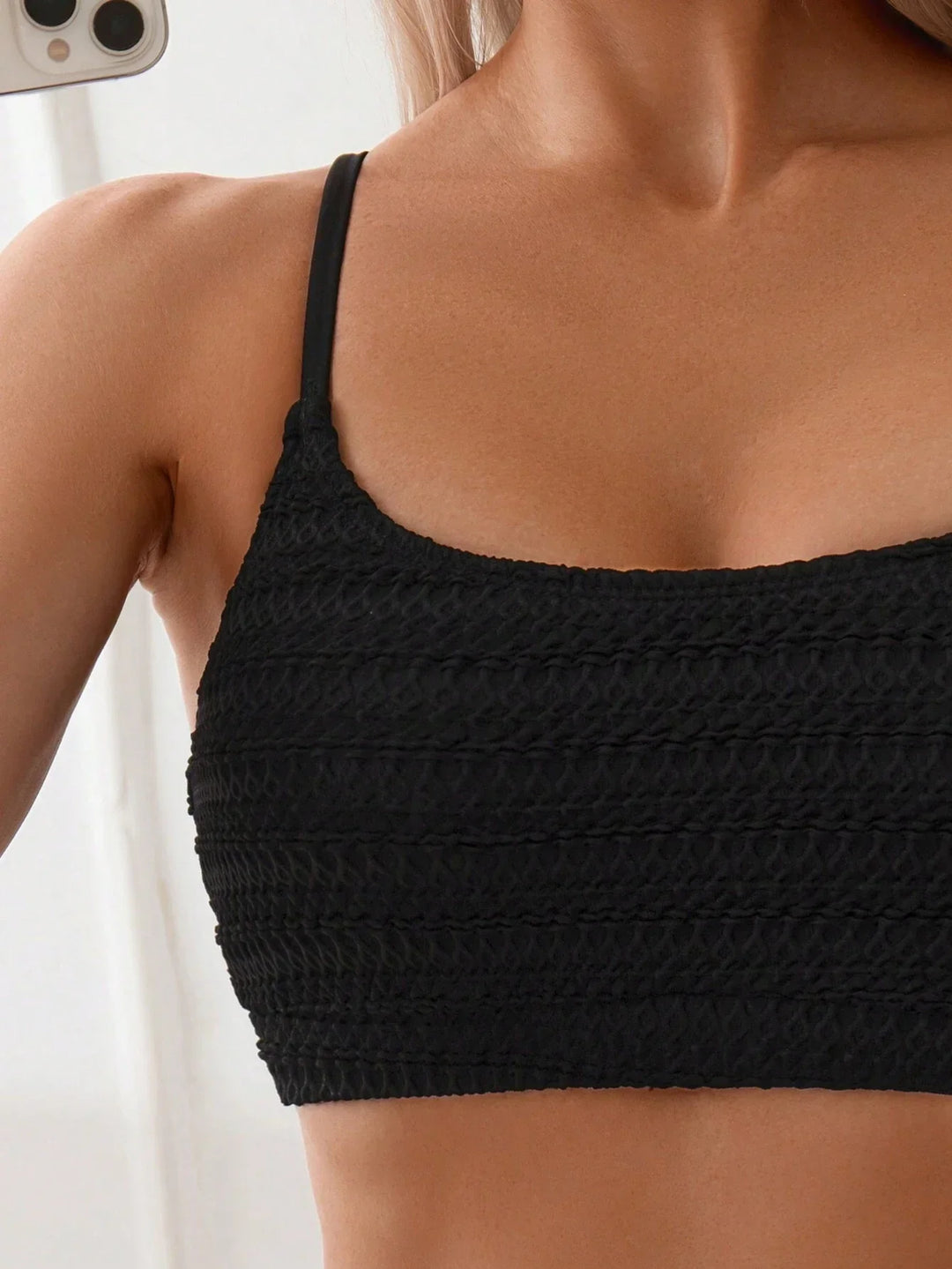 Elegant women's high-waisted black bikini with textured fabric, a flattering two-piece for summer.