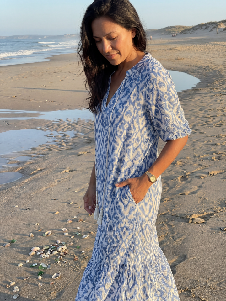 Bohemian women's blue geometric midi dress with short sleeves, V-neck & tassel detail, coastal summer style.