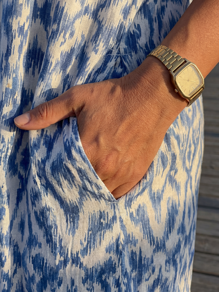Casual pull-on women's coastal midi dress, blue geometric print, short sleeves, V-neck, relaxed summer fashion.