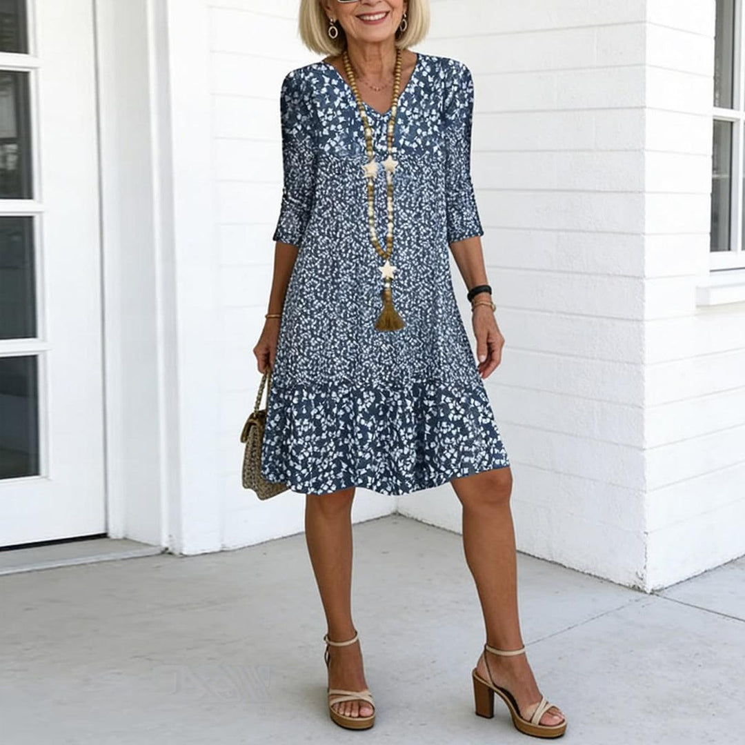 Women's blue floral print V-neck mini dress with ruffle hem. Perfect summer casual style.