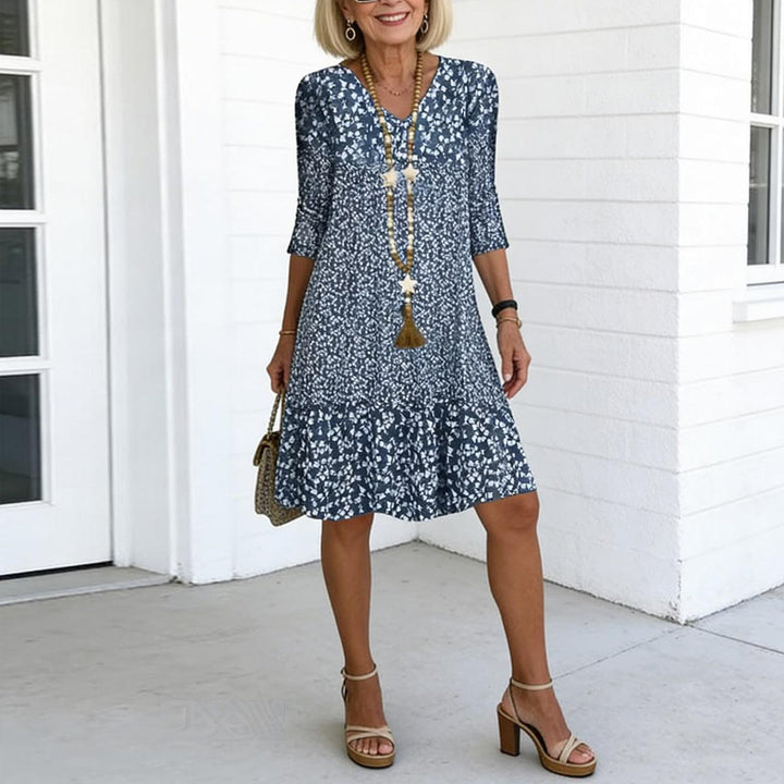 Women's blue floral print V-neck mini dress with ruffle hem. Perfect summer casual style.