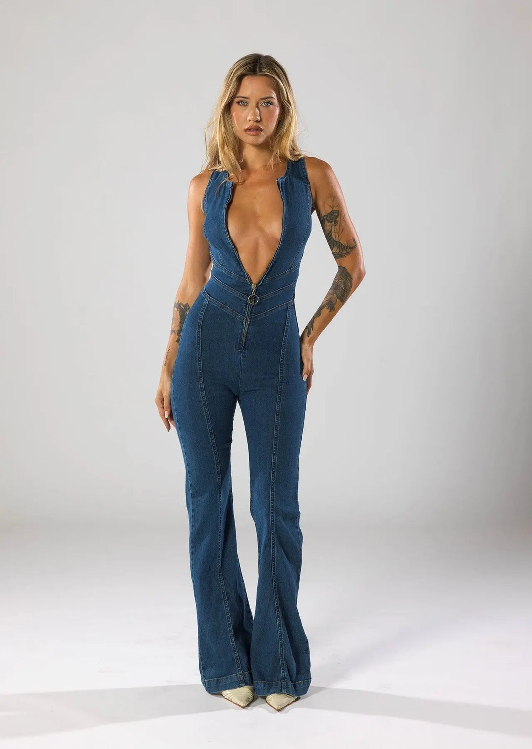 Women's blue plunge neck fitted flared jumpsuit. Elegant sleeveless one-piece for party & night out.