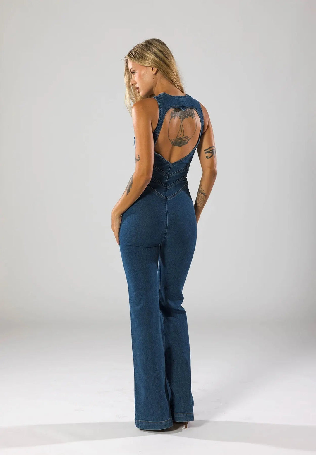 Blue women's fitted plunge neck jumpsuit with flared legs. Stylish one-piece for evening wear & streetwear.
