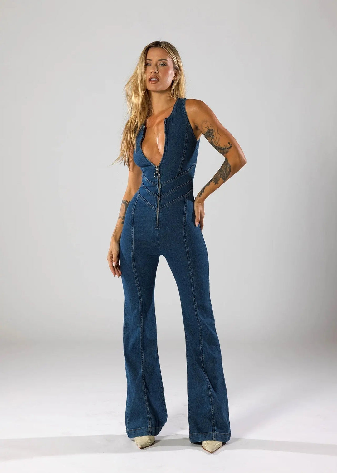 Elegant women's sleeveless plunge neck jumpsuit. Fitted blue one-piece with flared legs for party fashion.