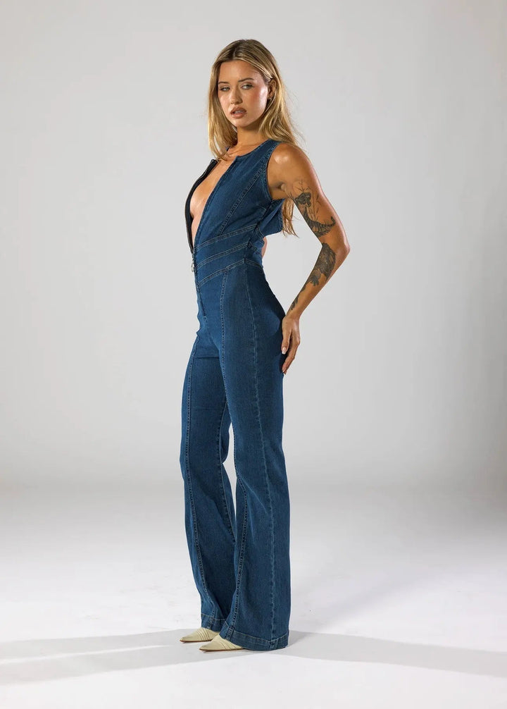 Women's fitted blue jumpsuit with a daring plunge neck and elegant flared legs. Ideal for night out & parties.
