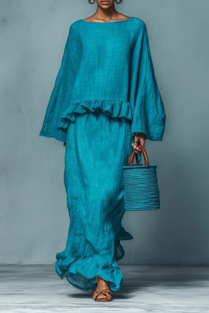 Women's blue ruffled maxi skirt and matching cape top set, perfect for a chic holiday or travel outfit.