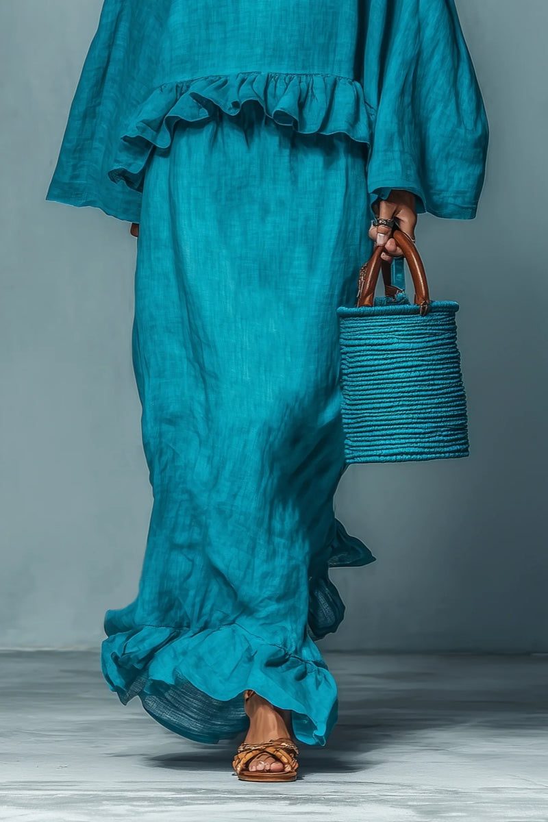 Stylish women's blue ruffled maxi skirt and cape top set, a comfortable holiday outfit or travel wear ensemble.