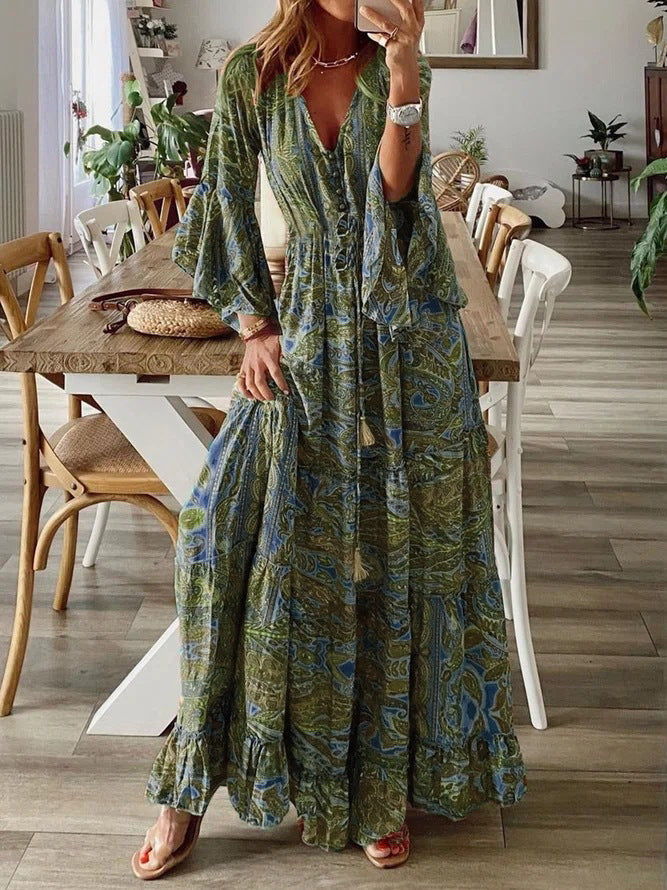 Elegant women's maxi dress featuring a vibrant paisley print and stylish flared long sleeves.