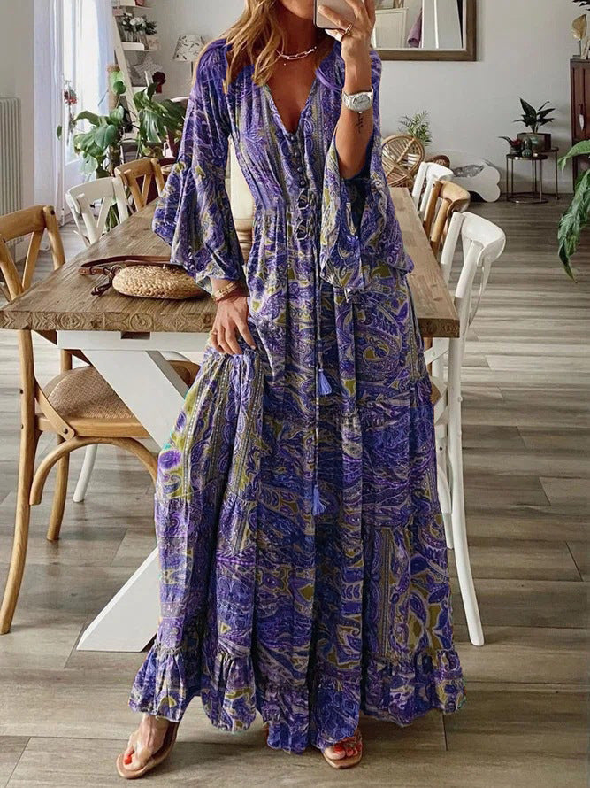Printed women's bohemian maxi dress with striking paisley design and dramatic flared long sleeves.