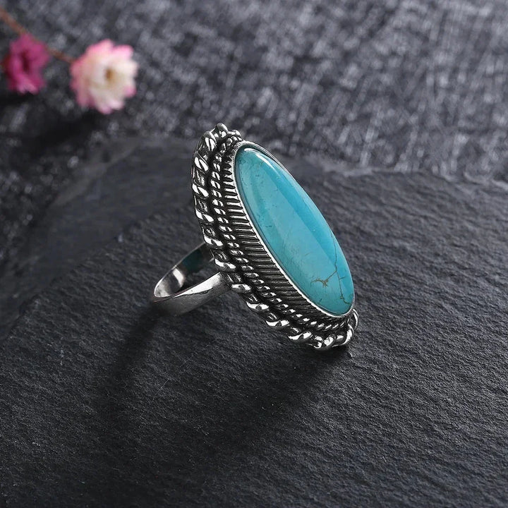 Bohemian women's ring: oval turquoise gemstone set in intricate braided silver-tone band.