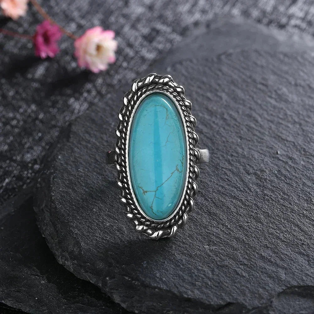 Stylish women's turquoise statement ring with an oval natural stone and braided silver design.