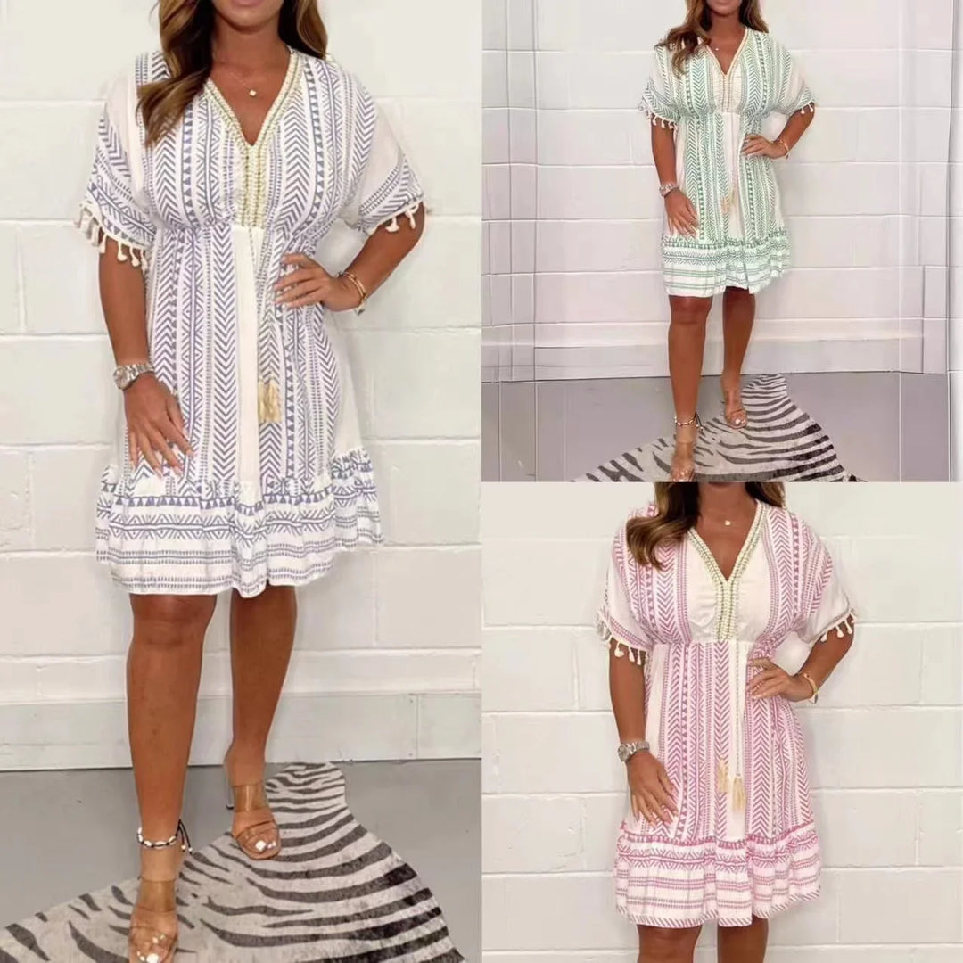 Lightweight women's summer boho mini dress featuring a playful print, V-neck, and tassel accents.