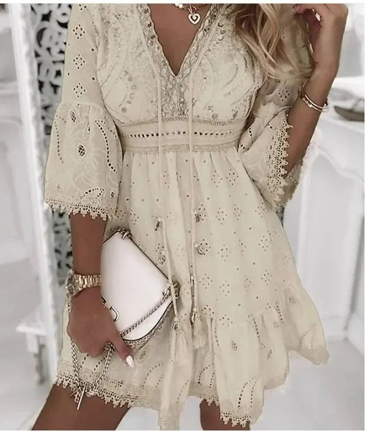 Short women's boho dress featuring a V-neck, tie front detail, and beautiful embroidered lace bell sleeves.