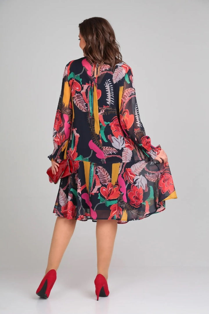 Woman posing in a flowy long-sleeve midi dress with a stunning bold floral print, ideal for any occasion.